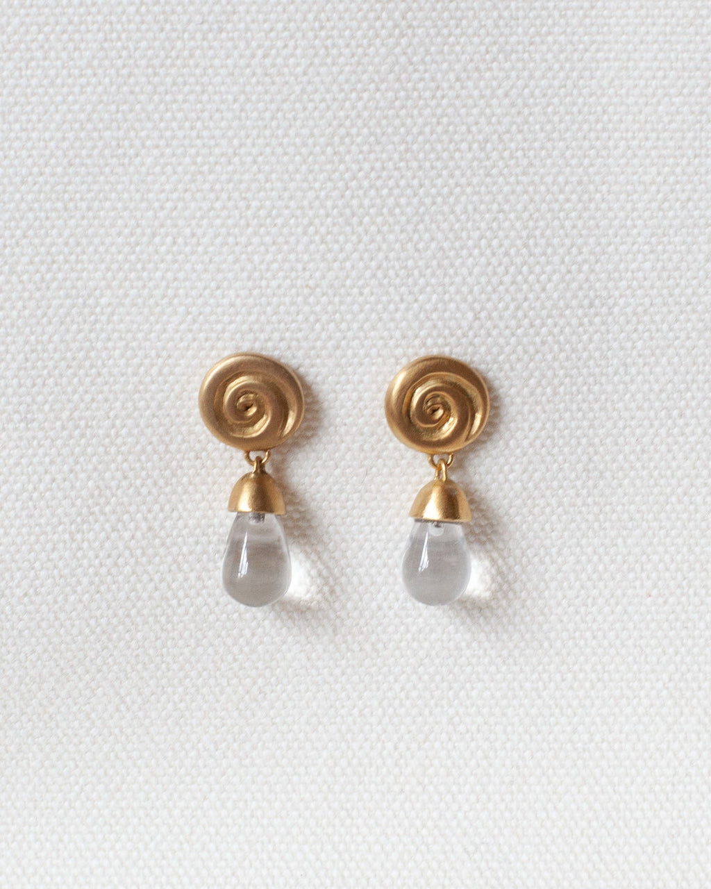 gold spiral earring with spiral design and crystal quartz drop