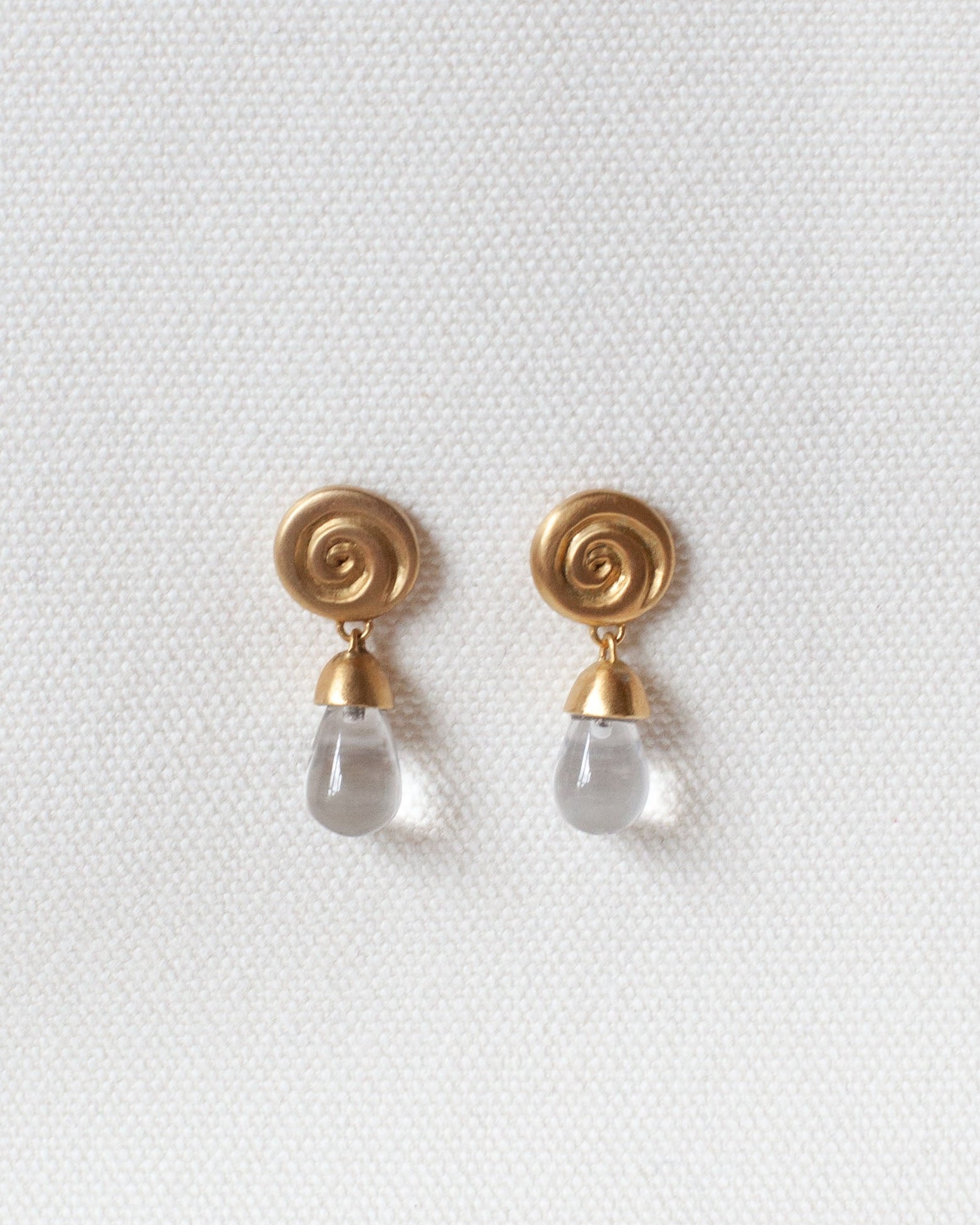 gold spiral earring with spiral design and crystal quartz drop